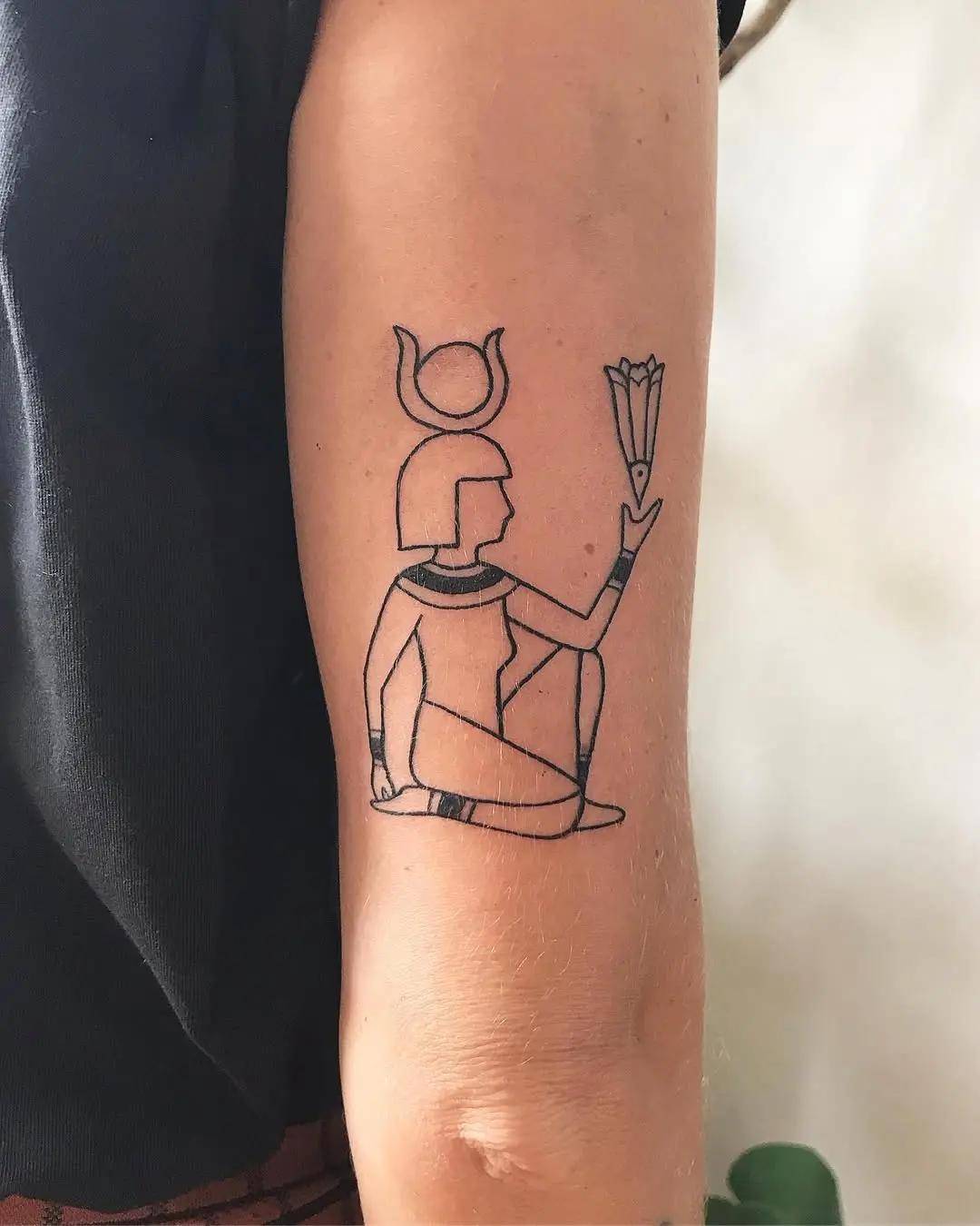 Stylish Egyptian goddess inked in minimalist design