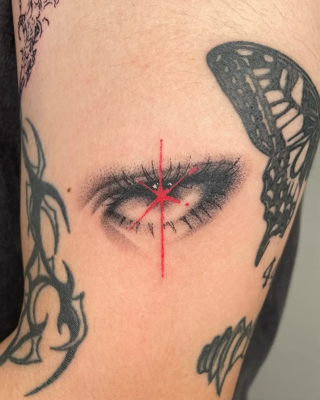 Intricate eye tattoo with striking red accents