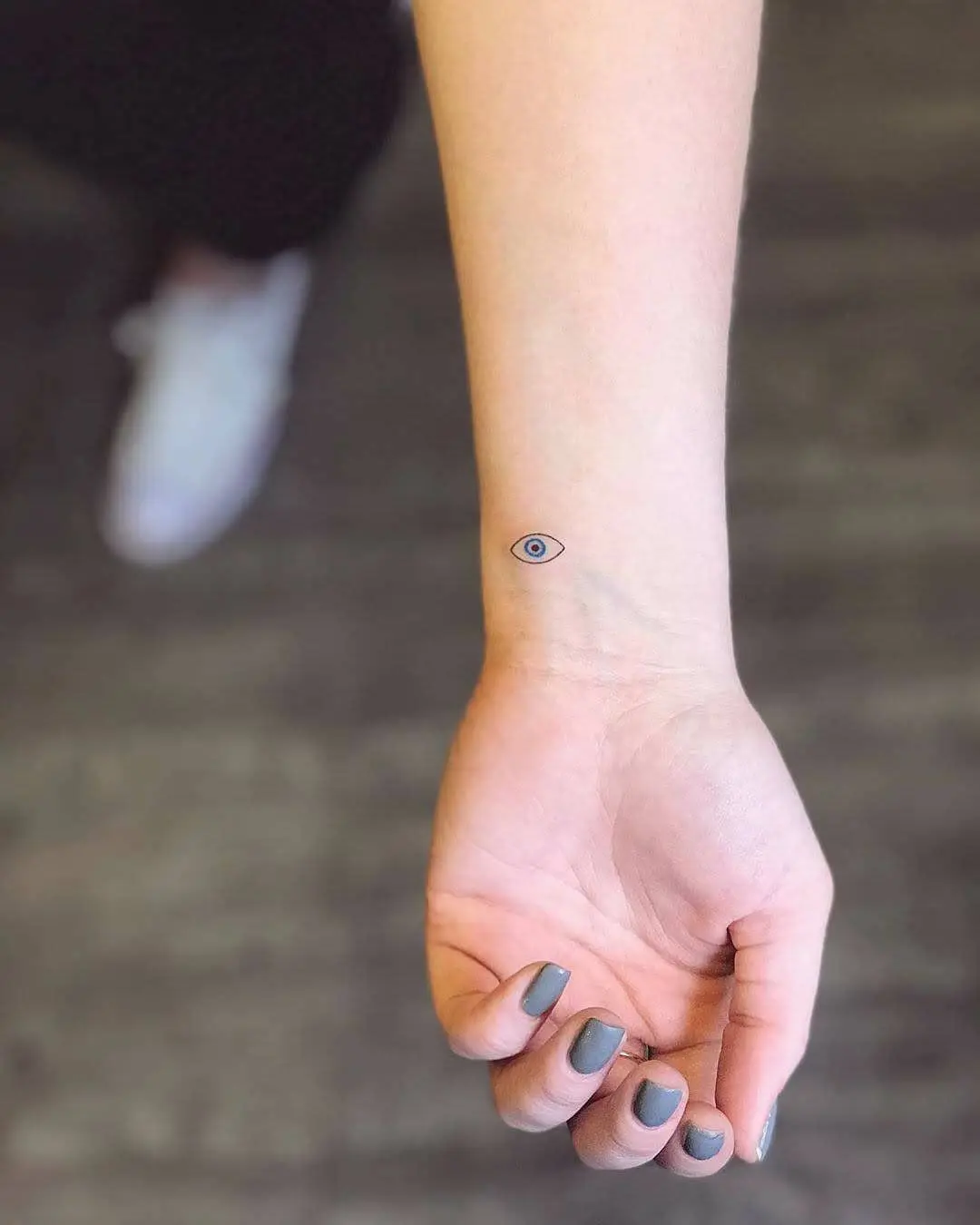 Minimalist eye tattoo design on the forearm
