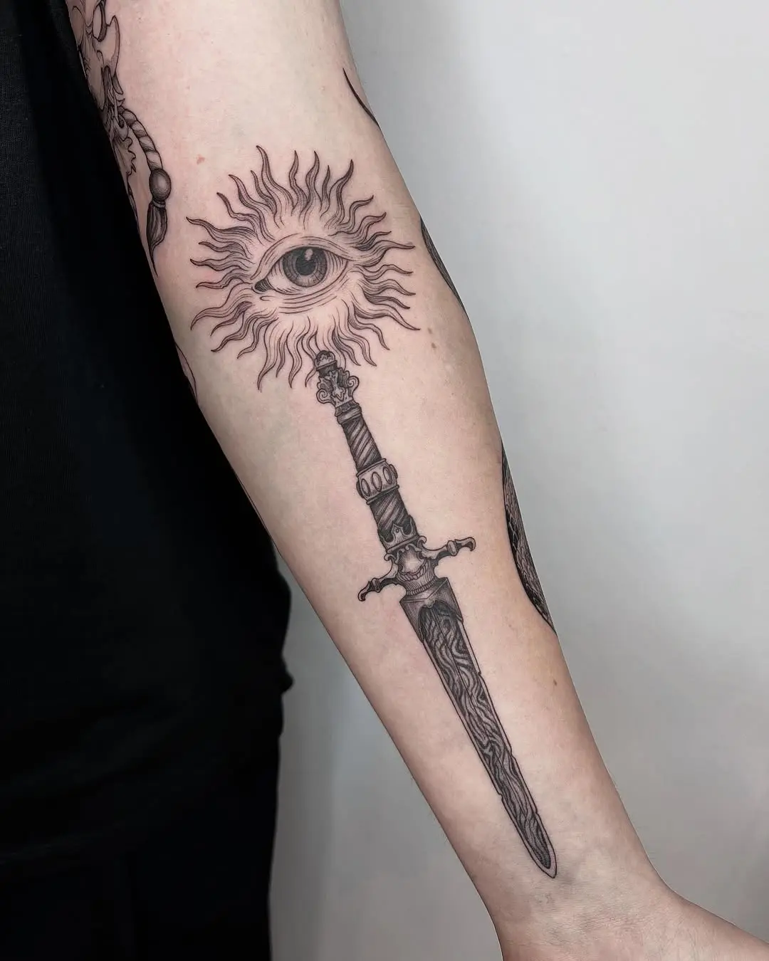 A unique eye and sword tattoo design