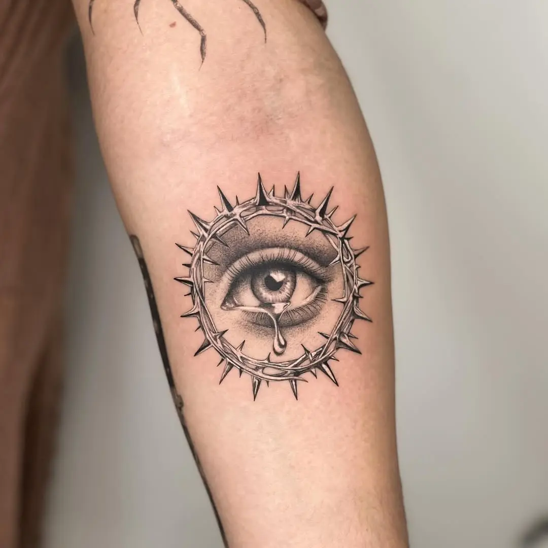 Intricate eye tattoo with thorny crown design