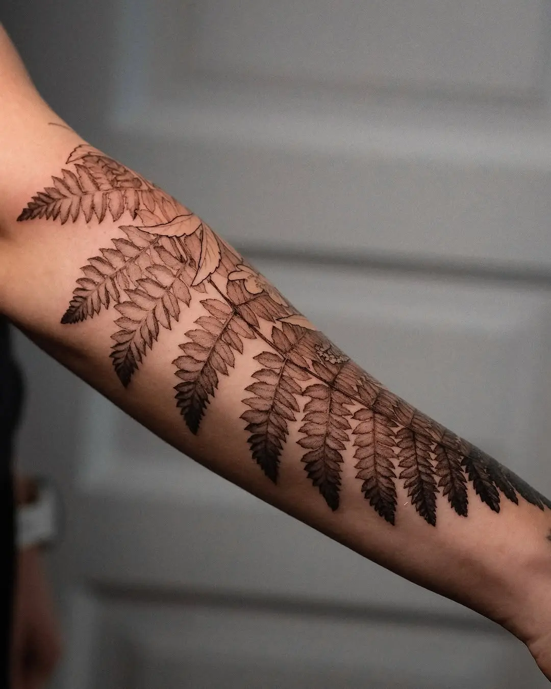 Intricate fern tattoo design on forearm