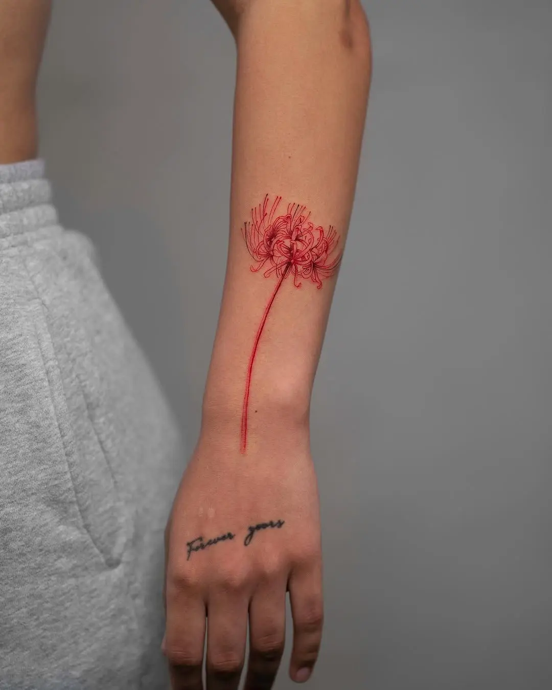 Stunning red flower tattoo on forearm