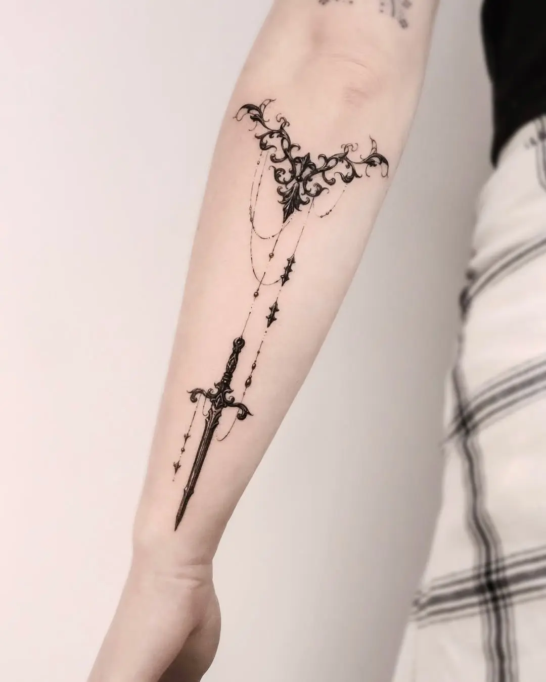 Intricate Floral Sword Tattoo on Forearm