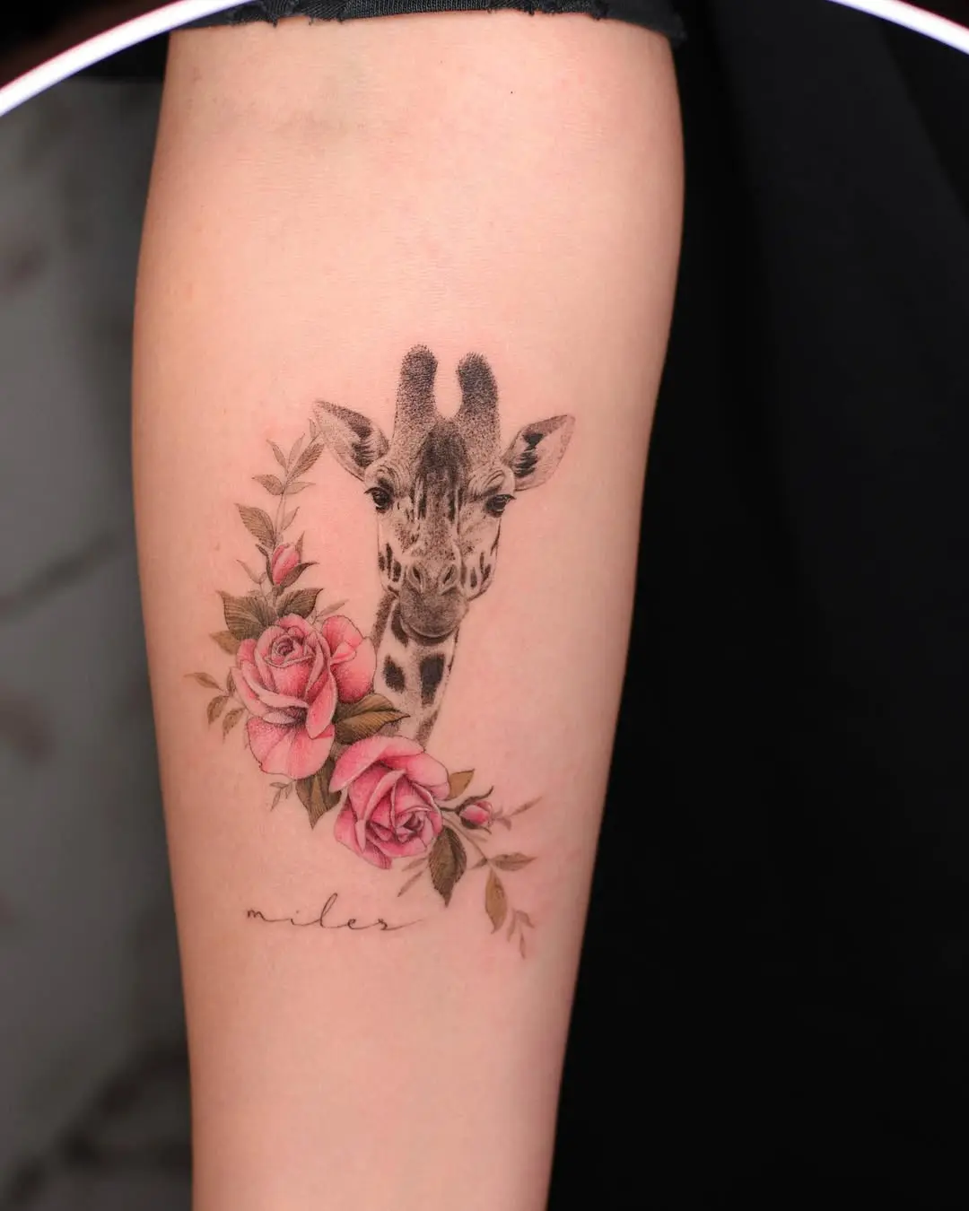 Charming giraffe tattoo with floral accents