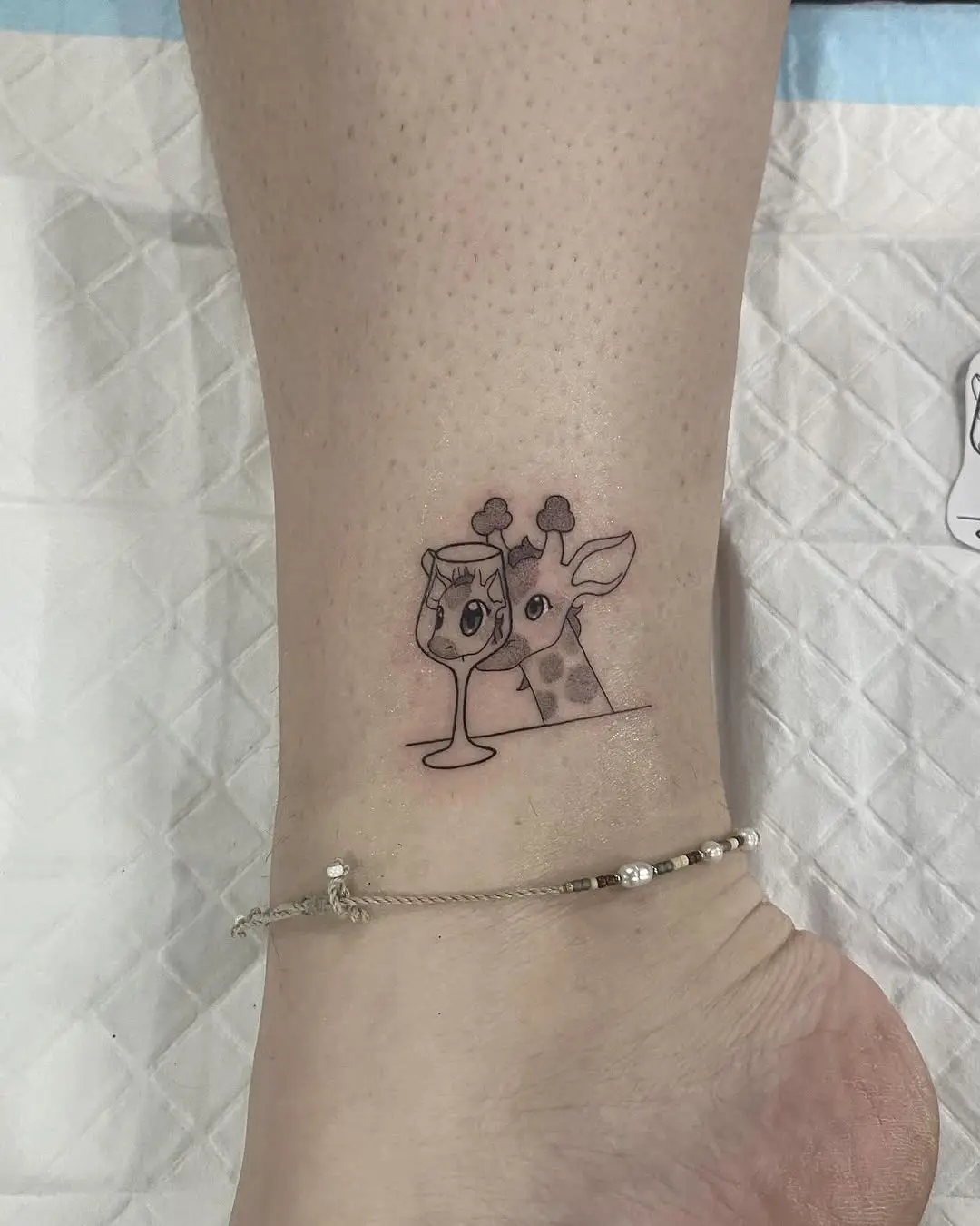 Adorable giraffe with whimsical drink tattoo