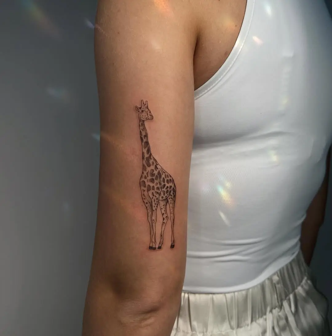 Minimalist giraffe tattoo on arm
