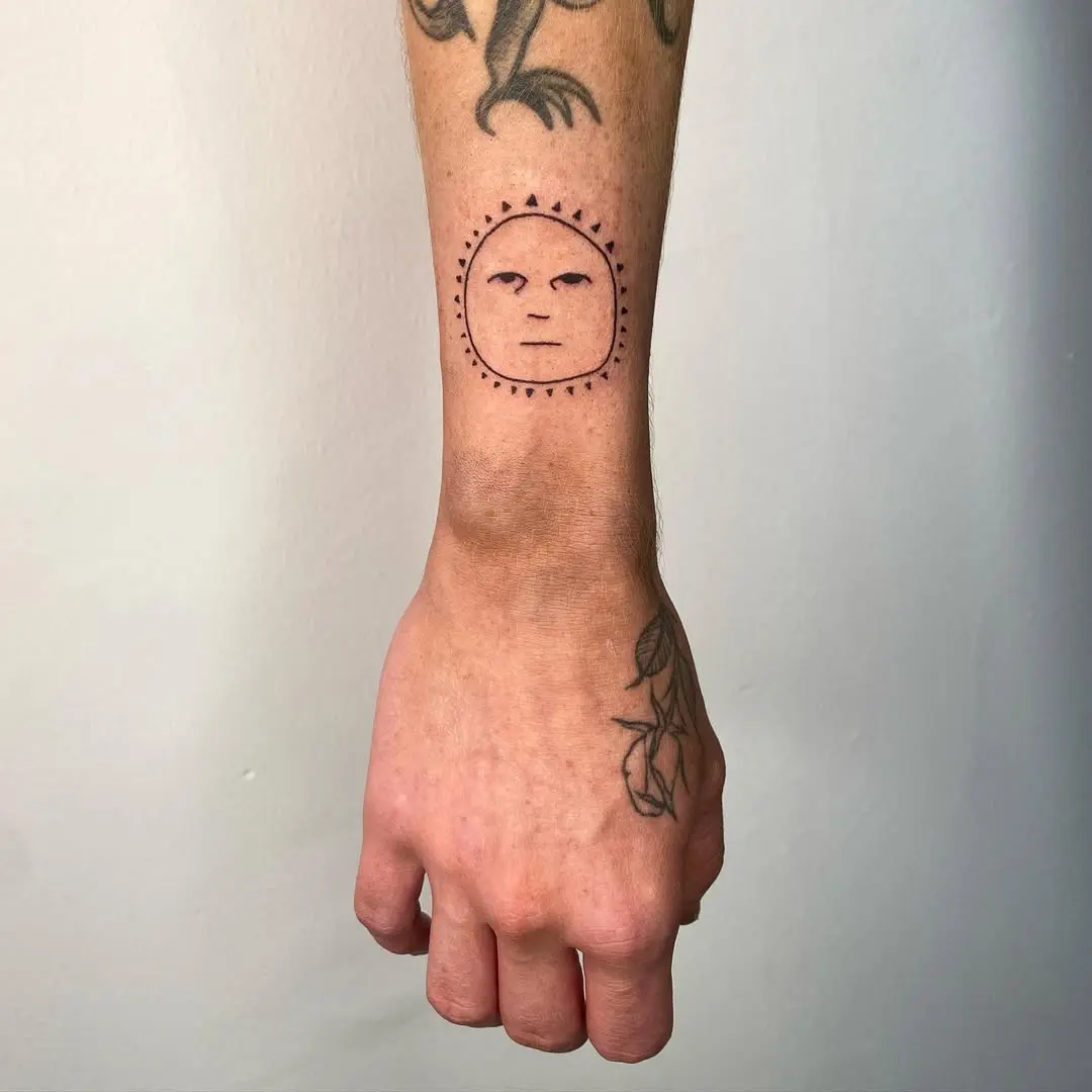 Cheerful sun tattoo radiating positive vibes
