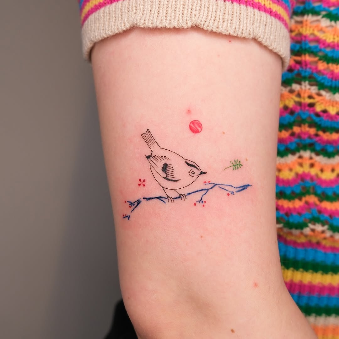 Charming bird tattoo perched on a branch