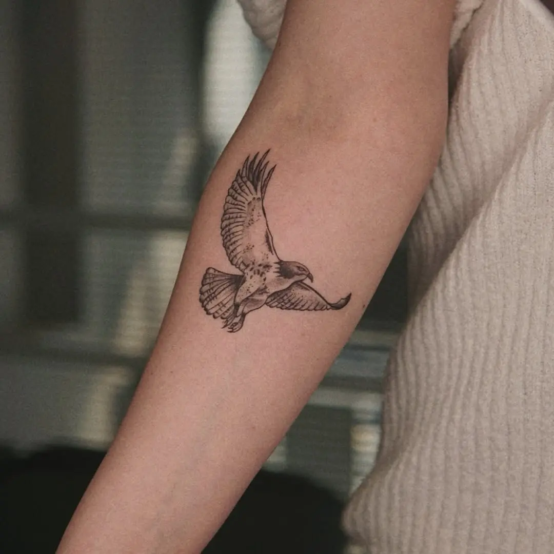 Elegant hawk tattoo soaring in flight