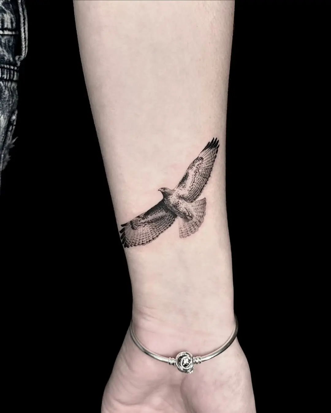 Intricate hawk tattoo in mid-flight pose.
