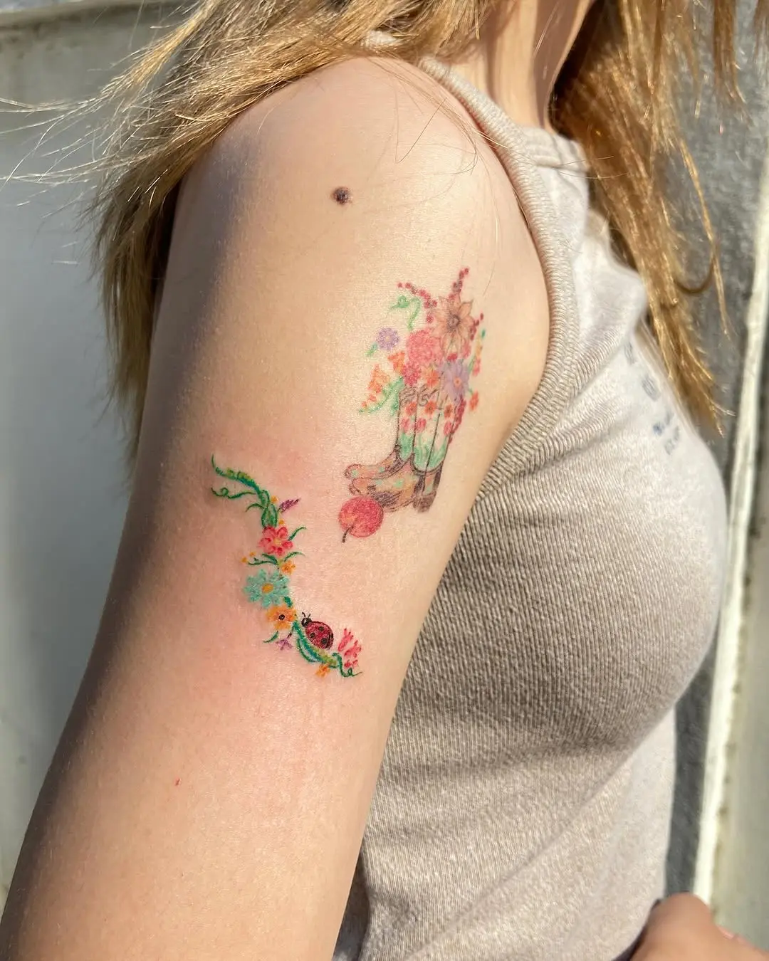 Enchanting floral ladybug tattoo design on arm