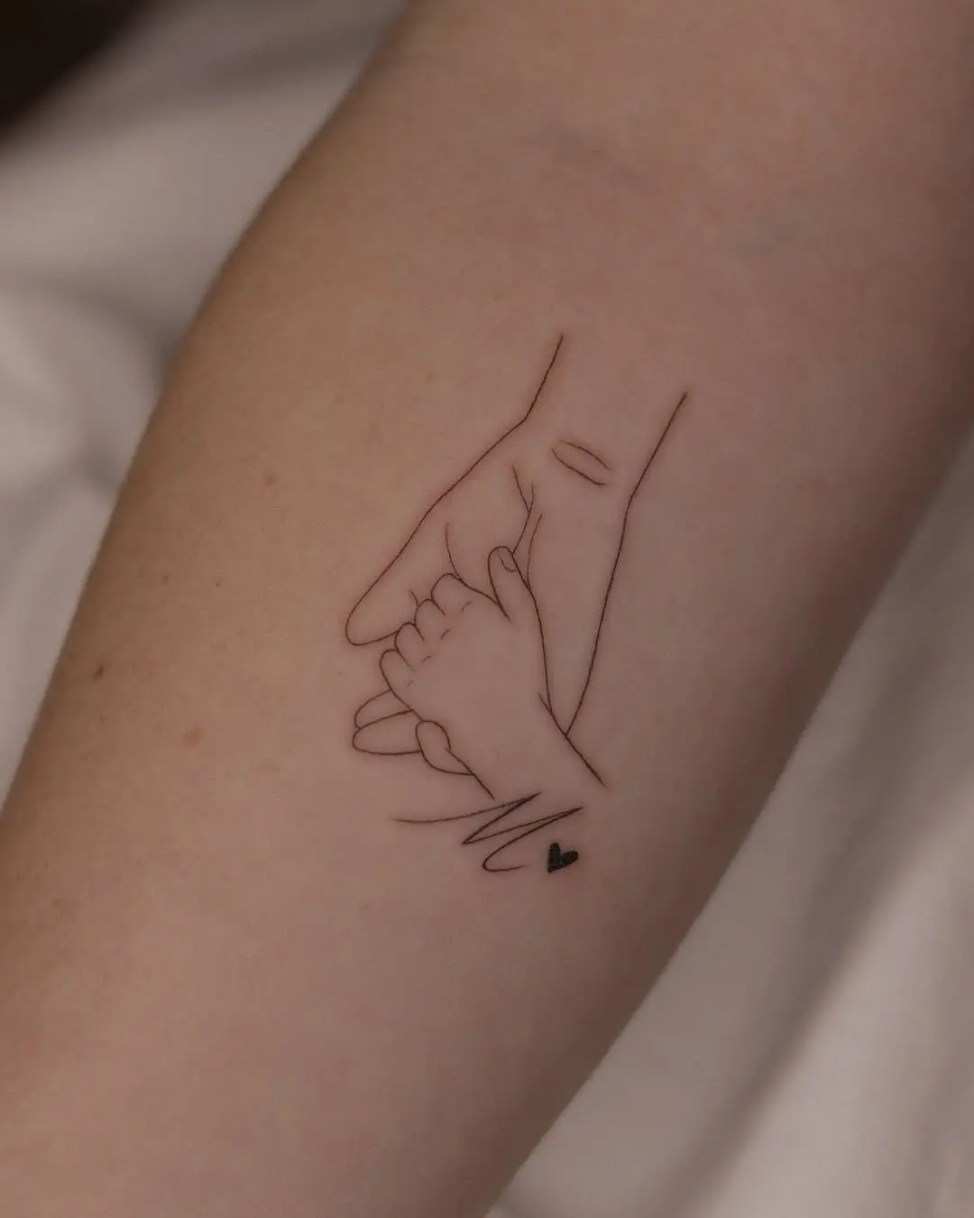 Elegant tattoo of a mother and child’s hands