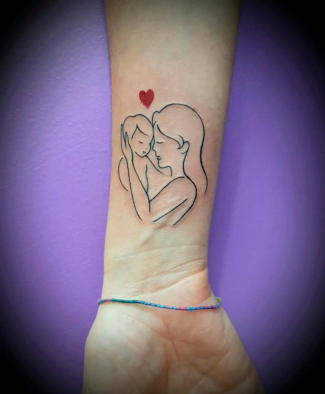 Tender mother-child tattoo with a heart.