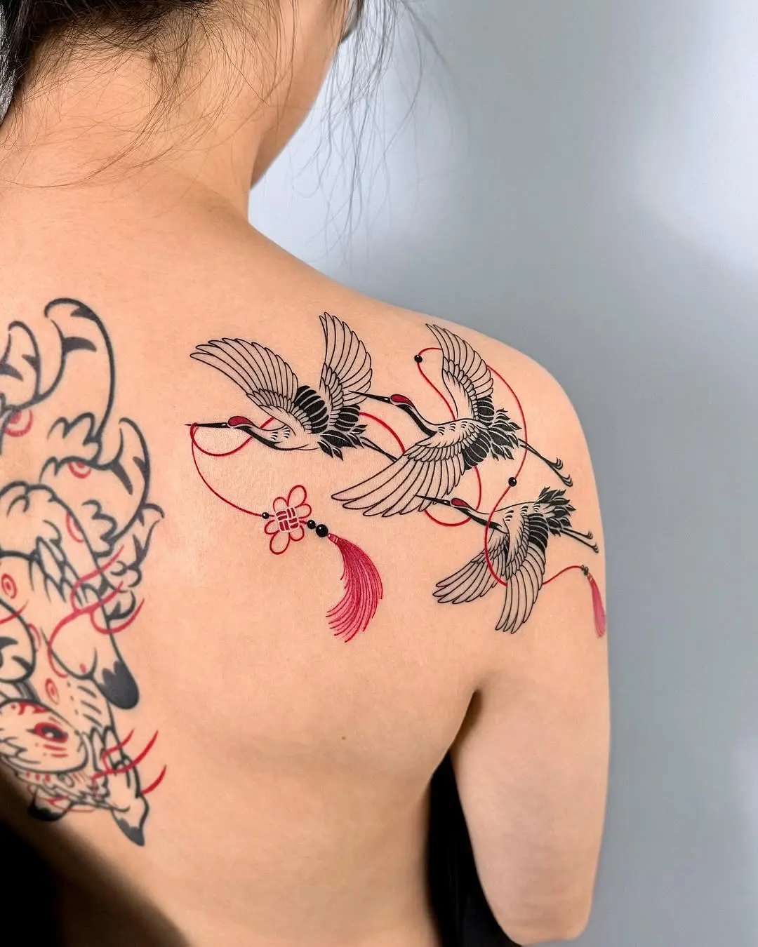 Elegant cranes intertwined with red threads