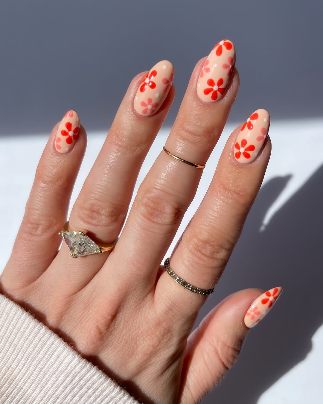 Bright peach nails with floral accents shine bright