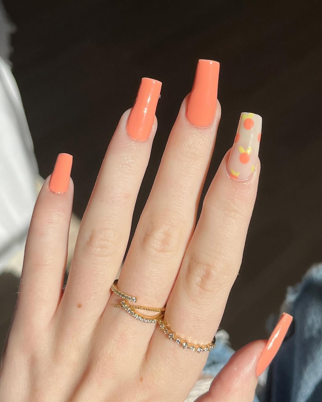 Vibrant peach nails with playful accents