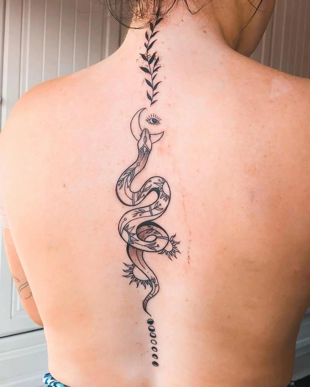 Elegant snake tattoo along the spine