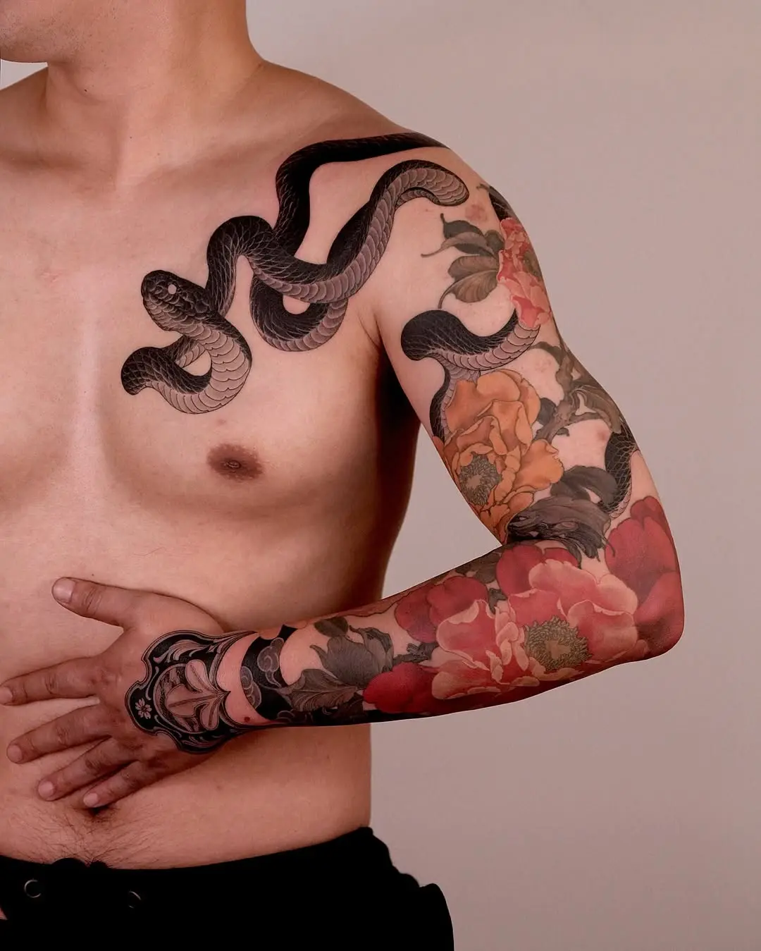 Elegant snake tattoo accentuated with flowers