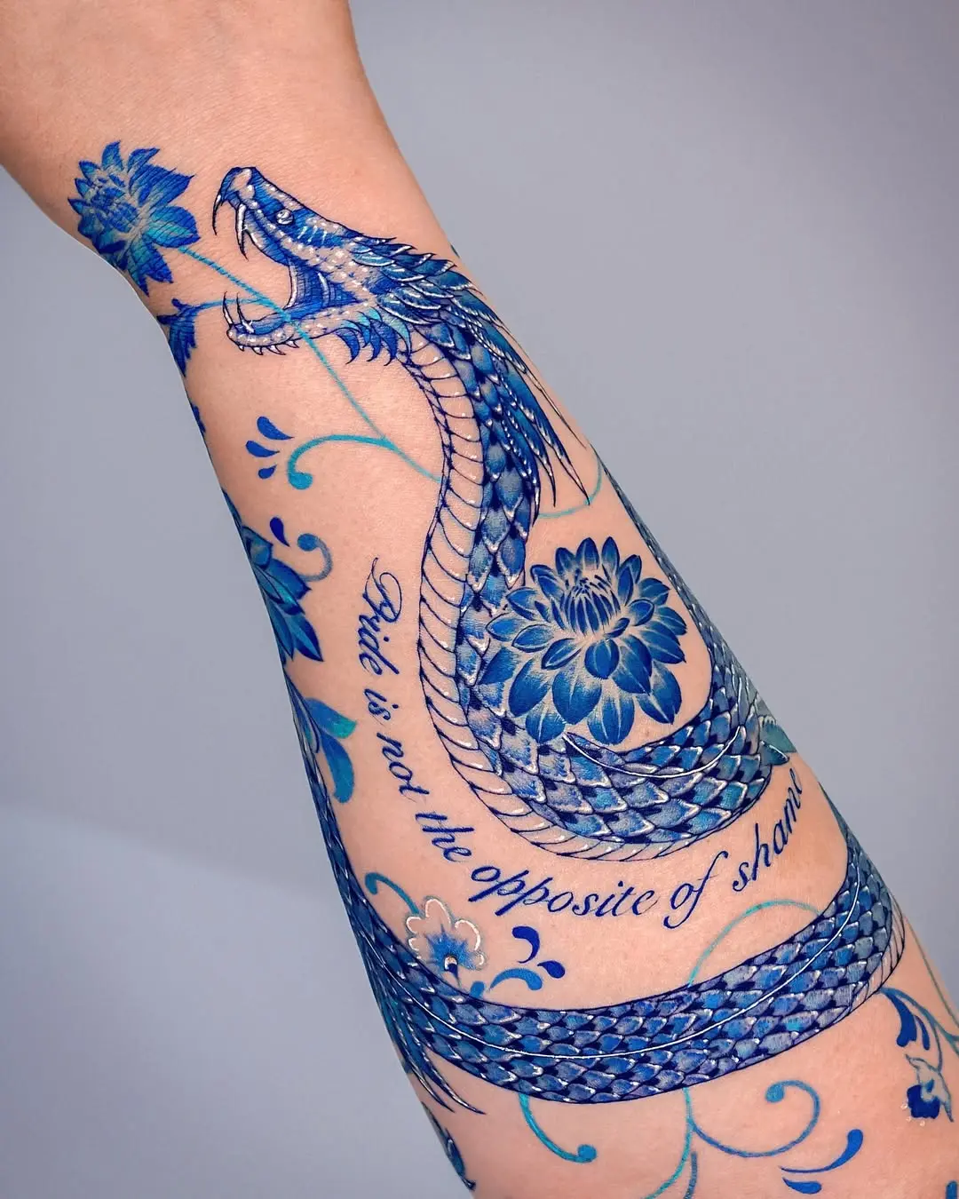 Stunning Blue Snake Tattoo with Floral Elements
