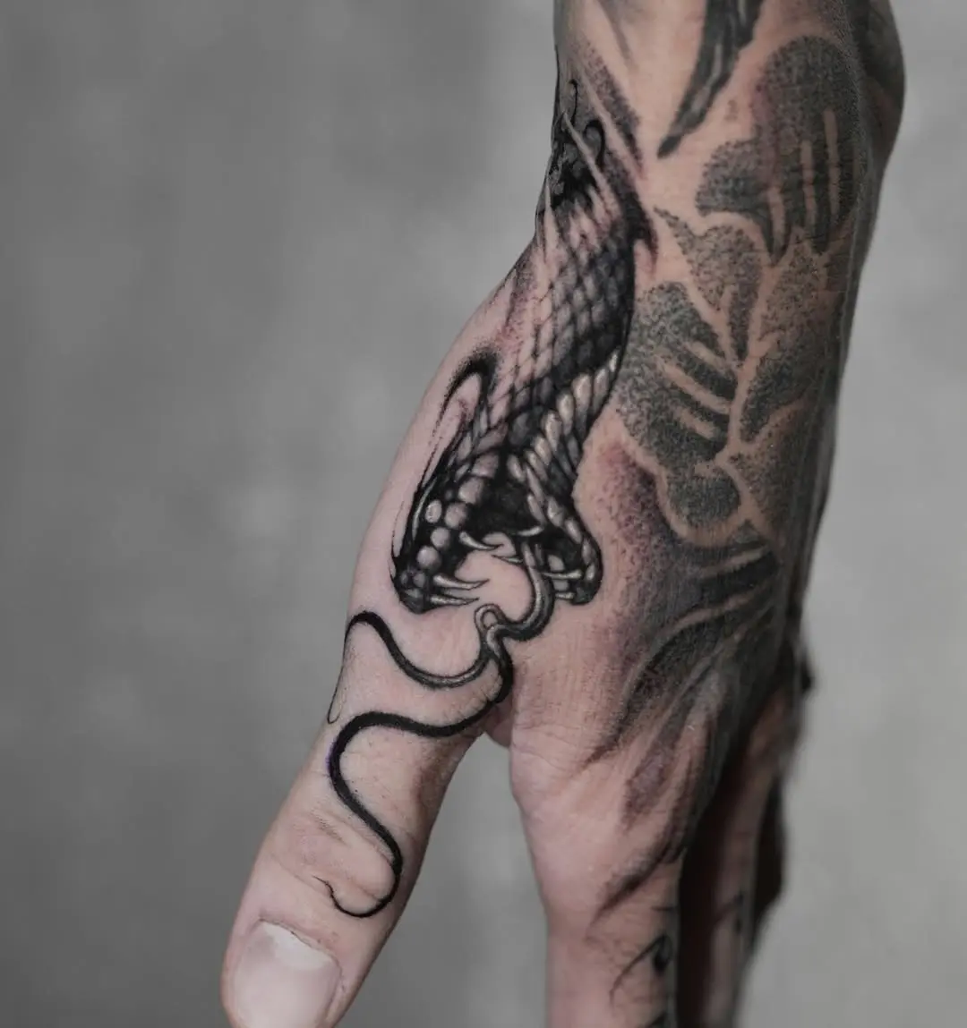 Intricate Black Snake Tattoo on Hand