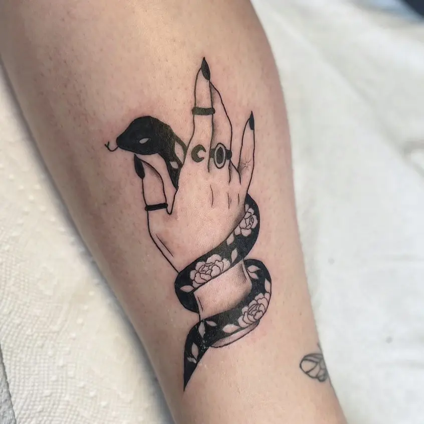 Creative snake tattoo entwined around a hand