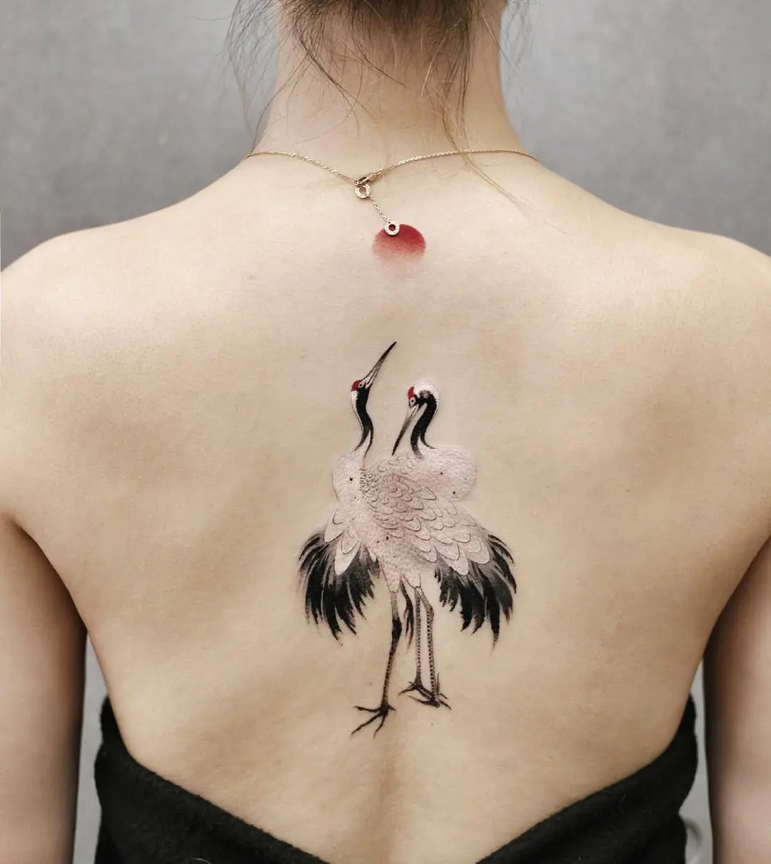 Elegant cranes adorned on the spine region