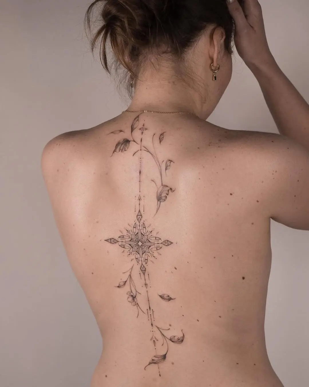 Delicate floral spine tattoo design with elegance