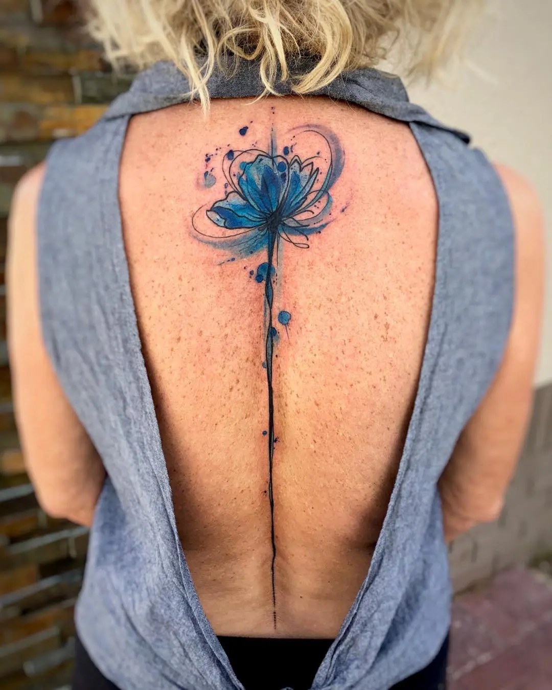 Elegant blue flower spine tattoo design