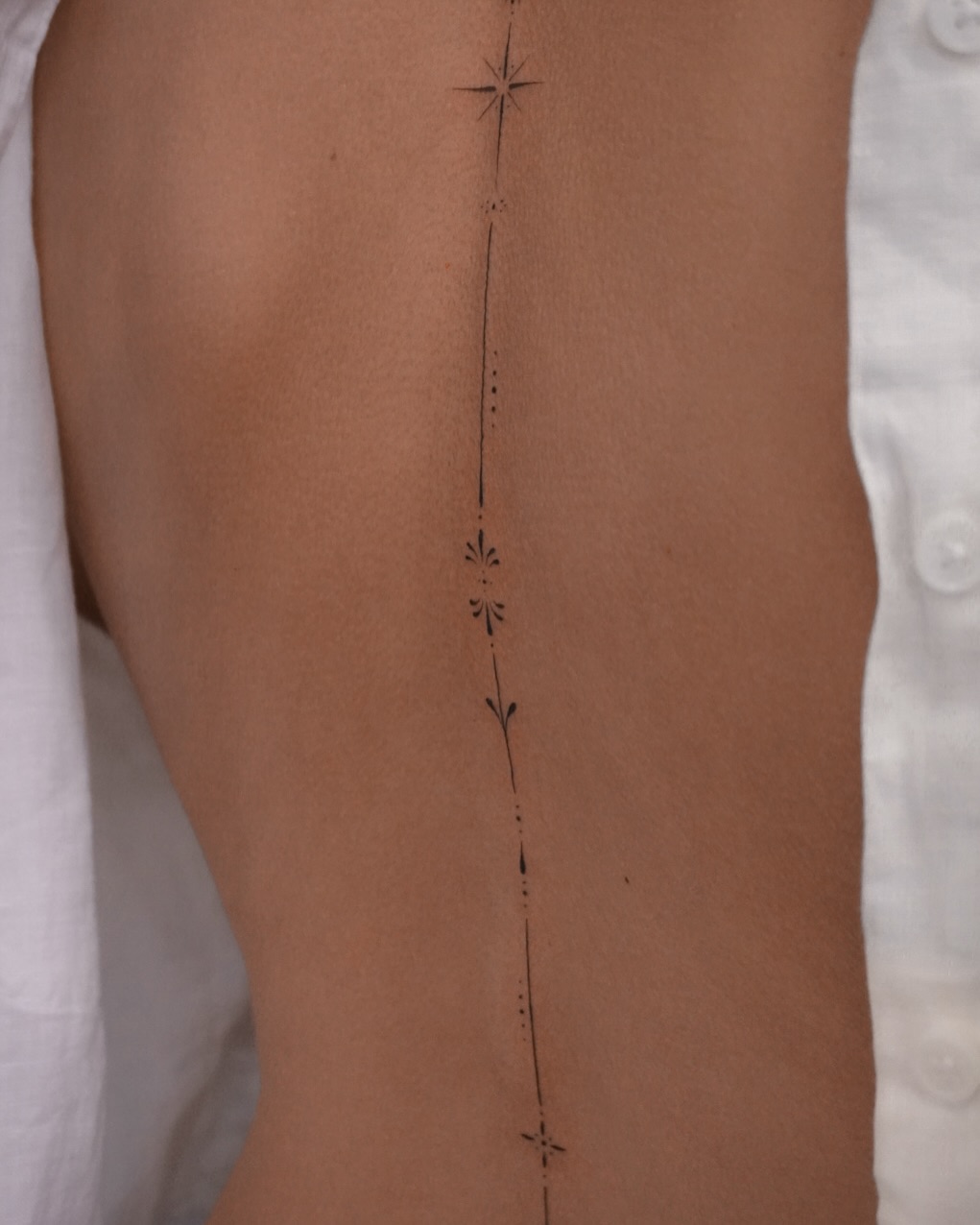 Elegant spine tattoo featuring floral accents