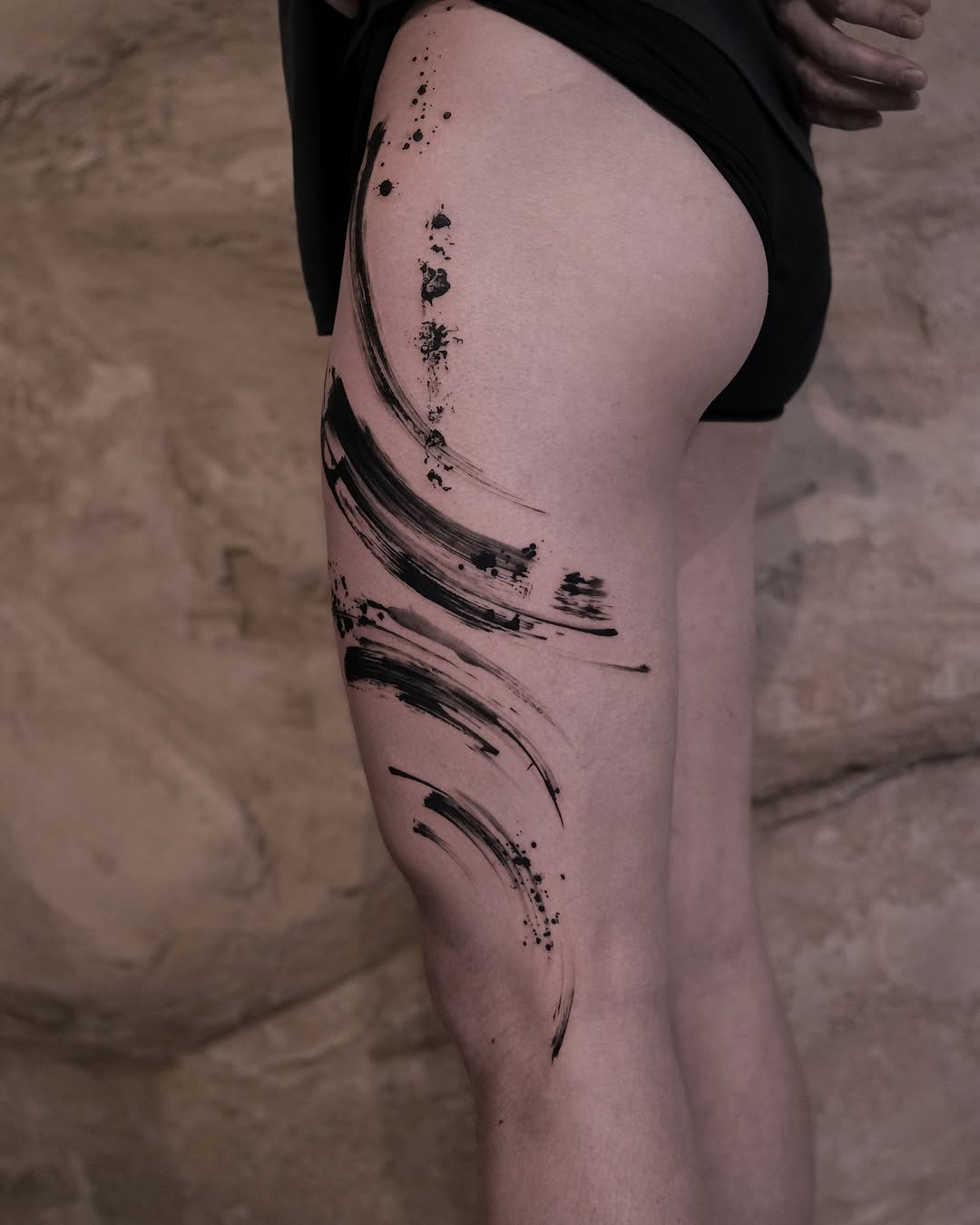 Bold abstract ink strokes on thigh