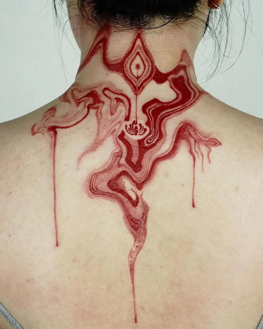 Fluid red patterns create striking tattoo design