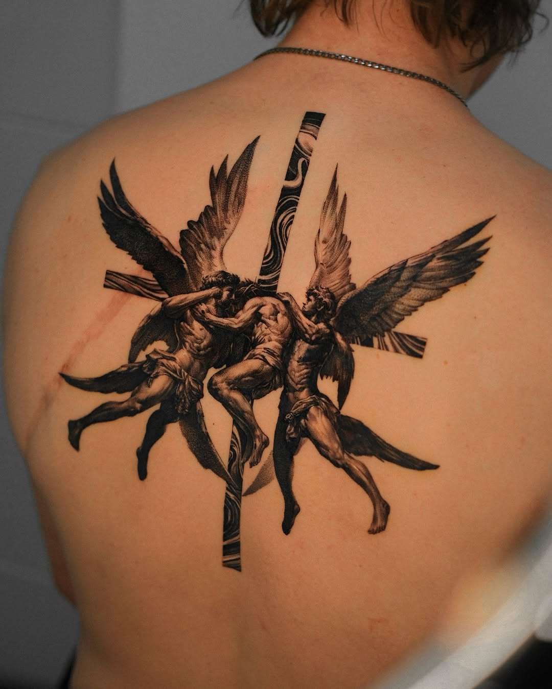 Dramatic angelic wrestling tattoo on the back