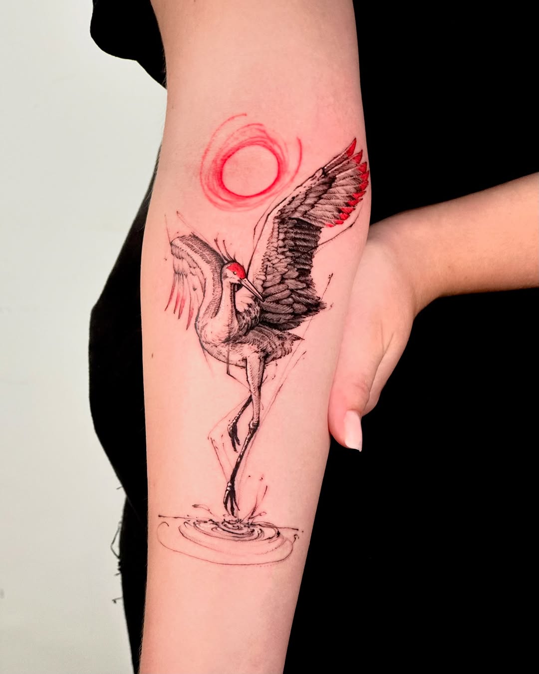 Elegant crane tattoo with red sun accent