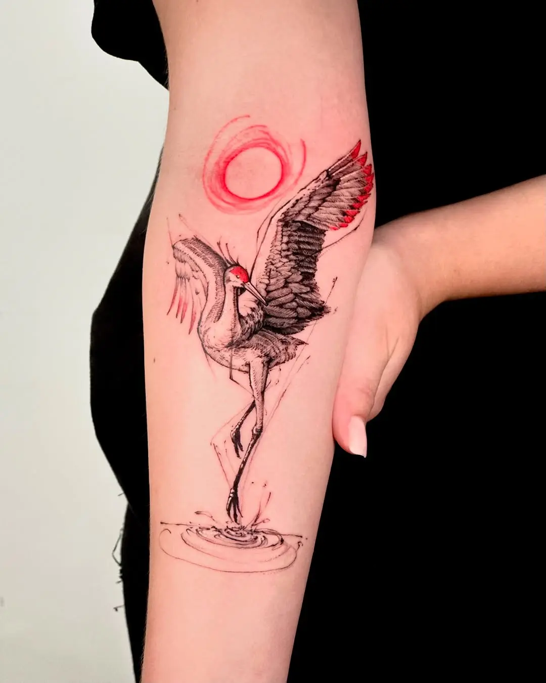 Elegant crane tattoo with red sun accent