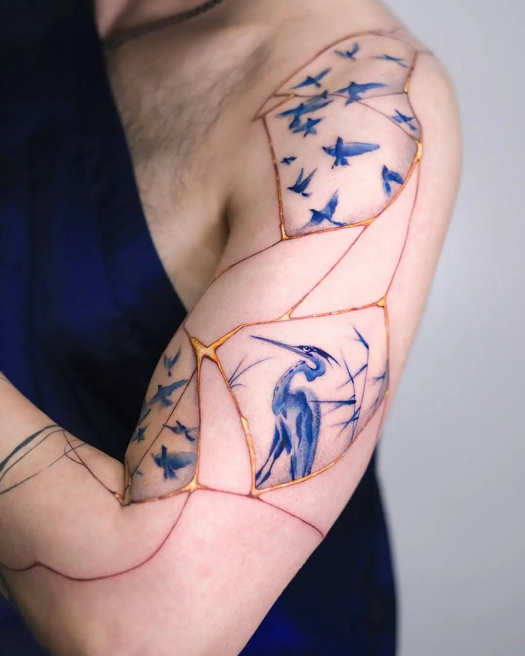 Unique bird and star tattoo composition on arm