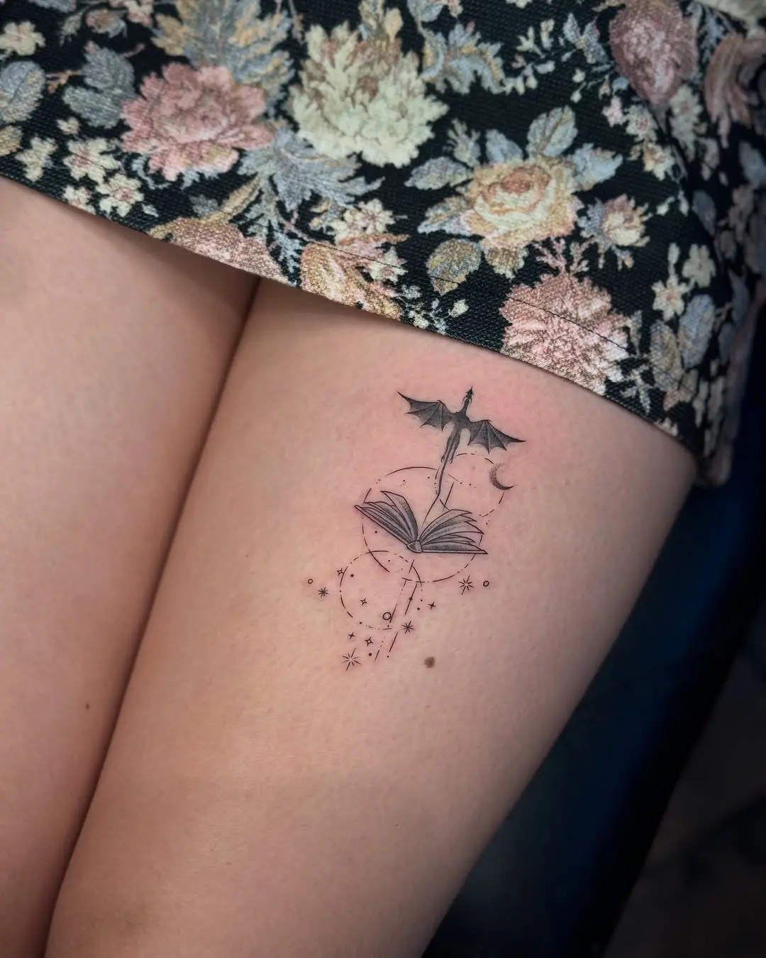 Enchanting book and bat thigh tattoo design