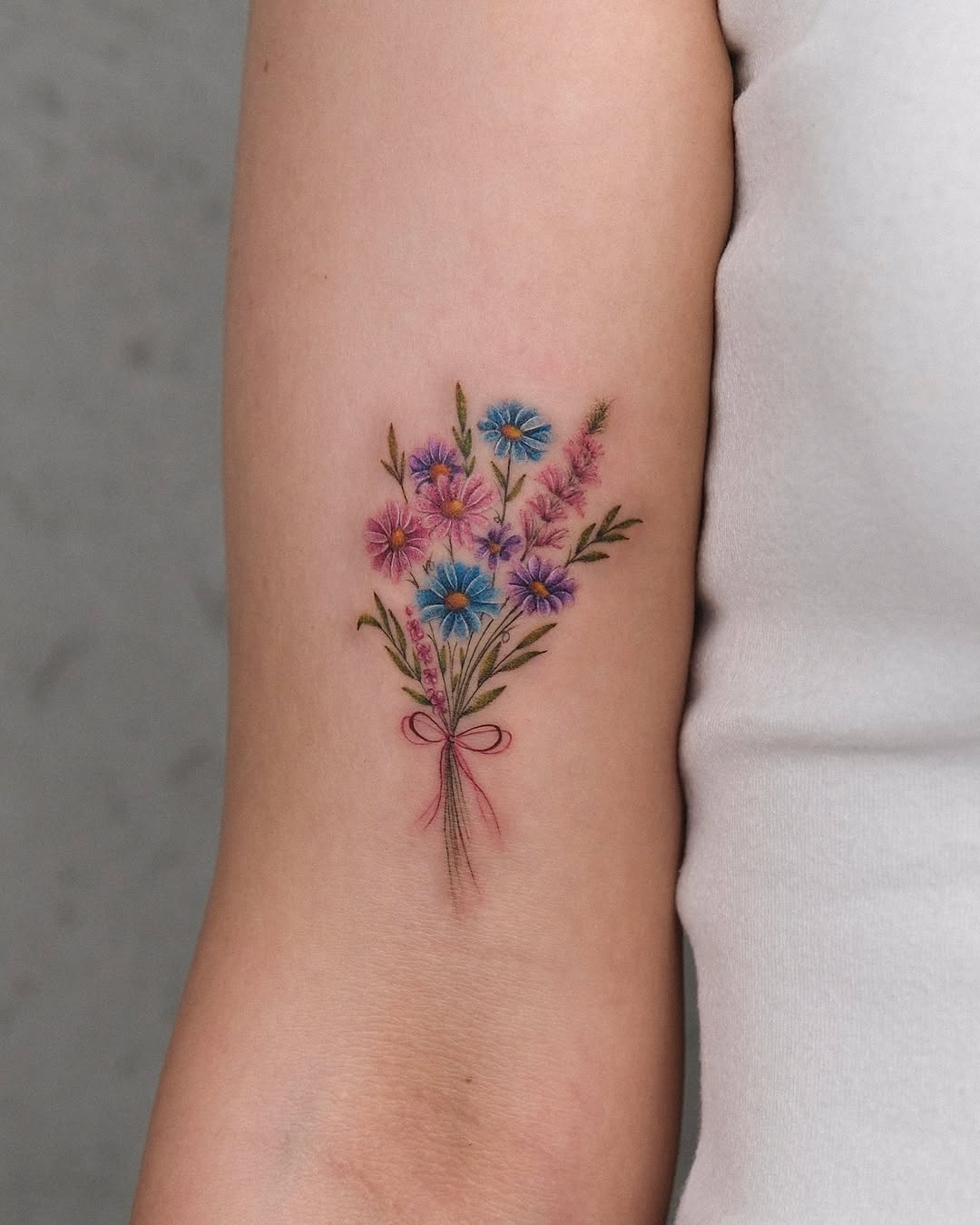 Delicate floral bouquet tattoo on the arm