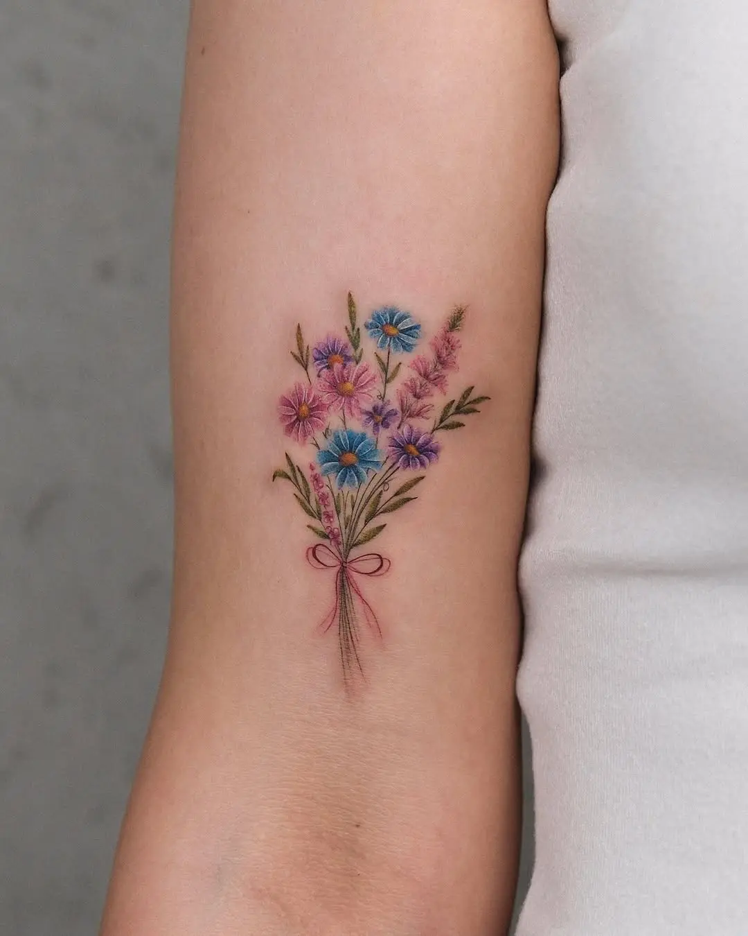Delicate floral bouquet tattoo on the arm
