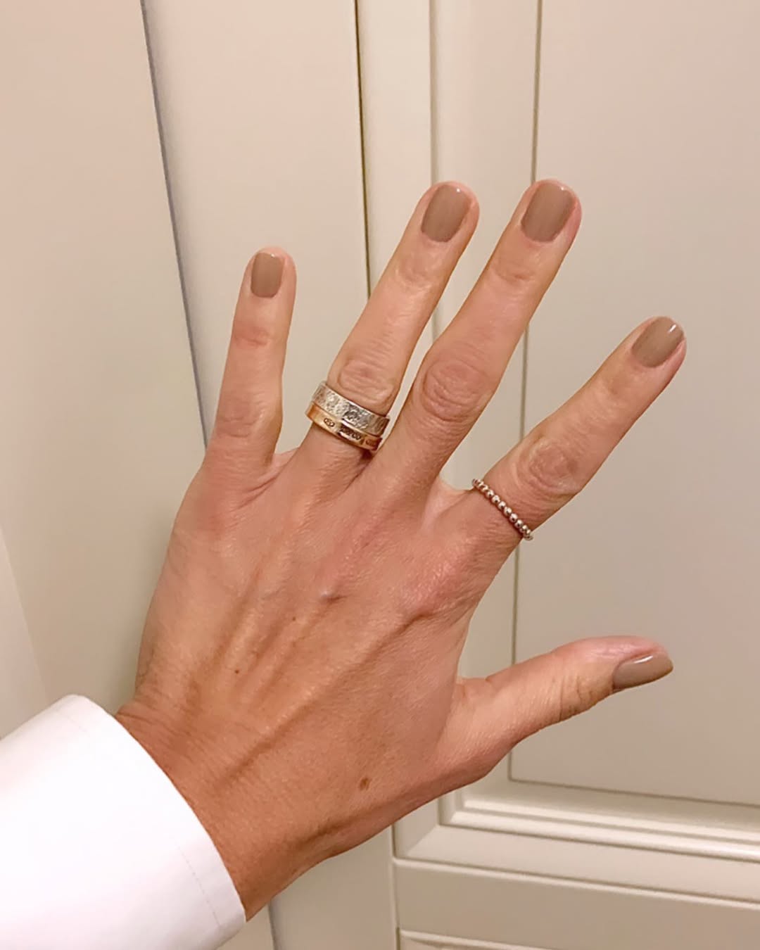 Elegant beige nails with minimalistic rings