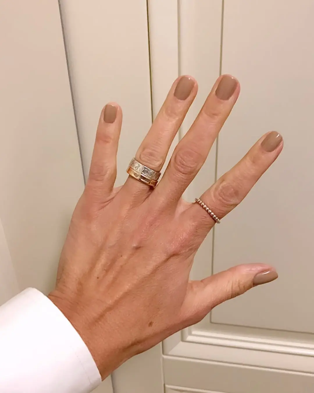 Elegant beige nails with minimalistic rings
