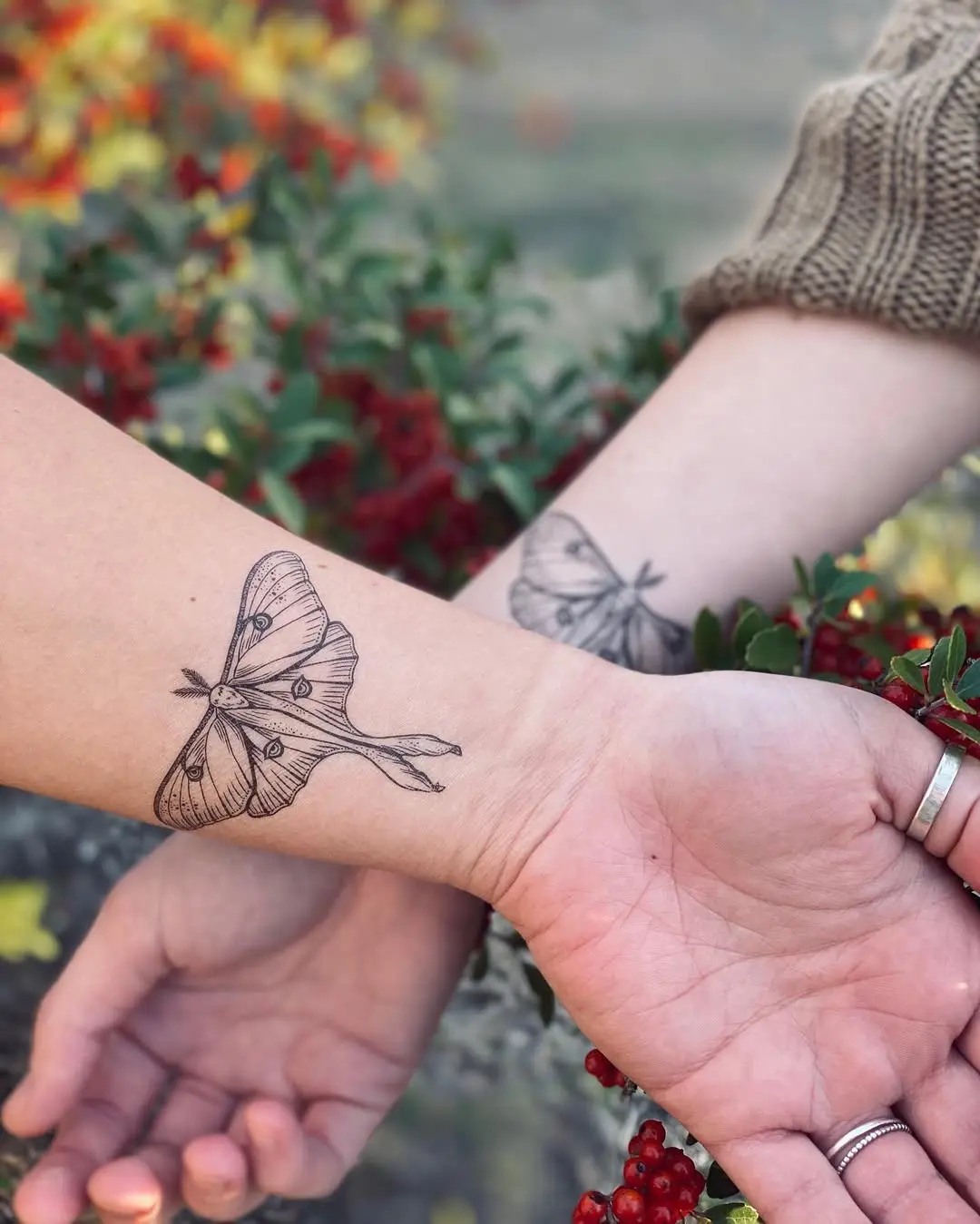 Elegant moth tattoos symbolizing friendship and connection