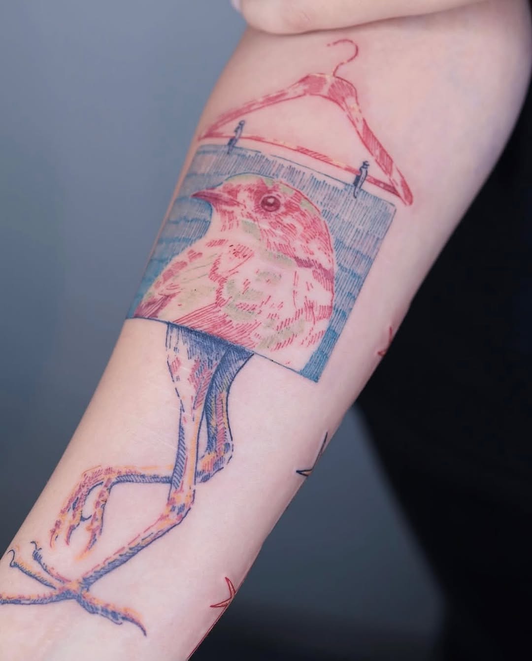 Unique tattoo of a bird in a frame
