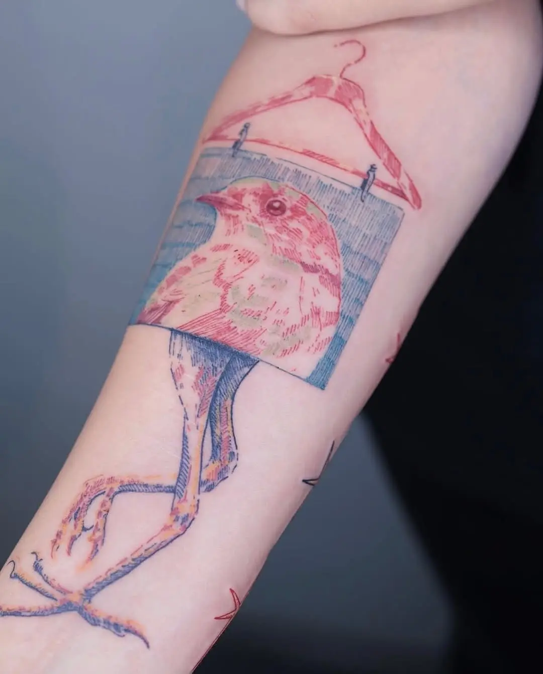 Unique tattoo of a bird in a frame