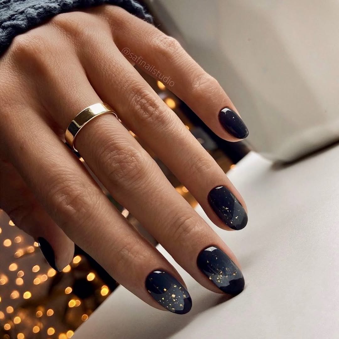 Elegant black nails with shimmering gold accents