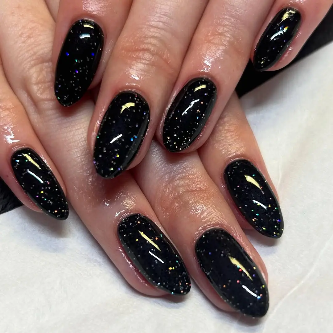 Elegant black nails with shimmering glitter accents