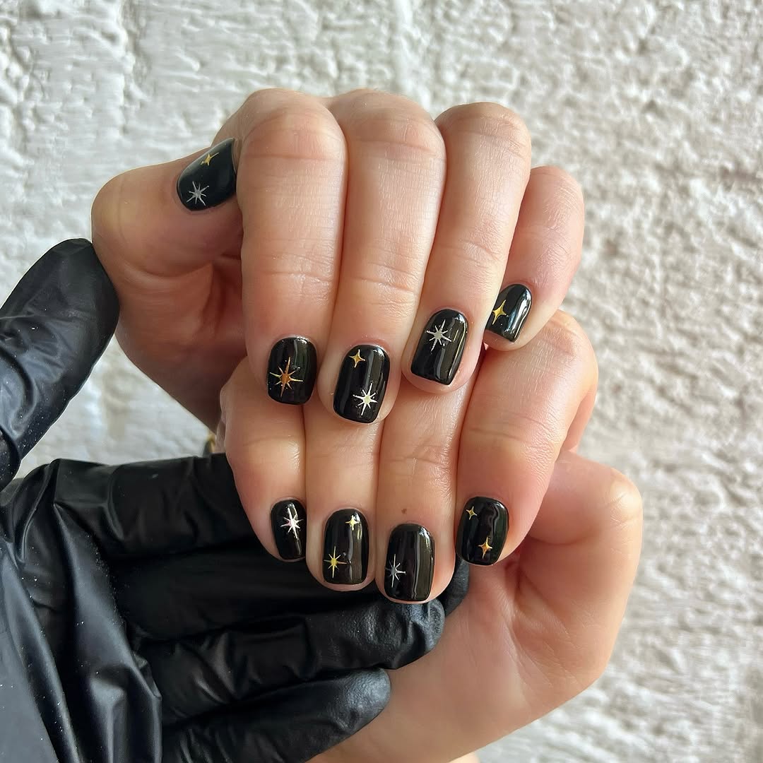 Elegant black nails adorned with star designs