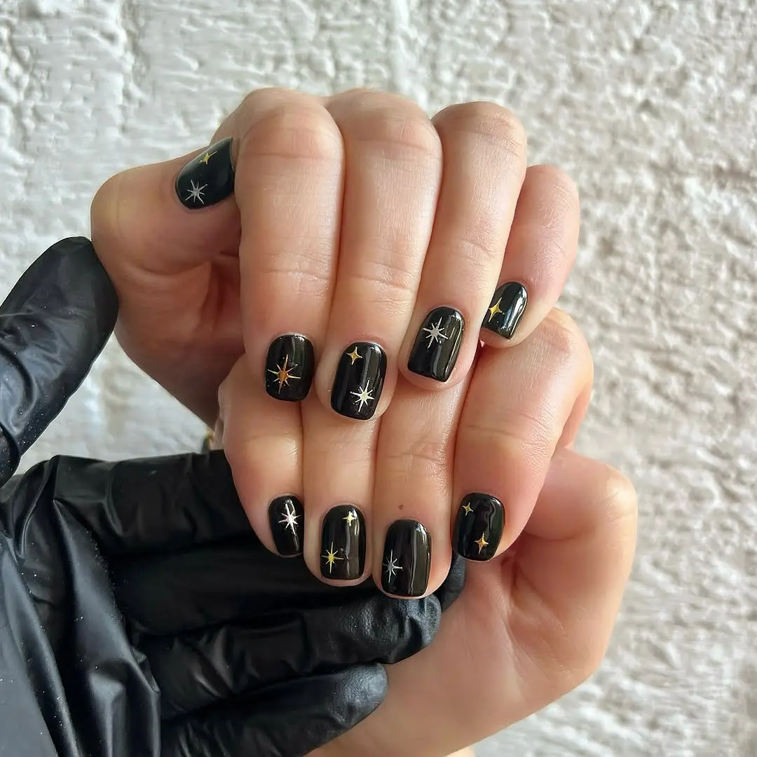 Elegant black nails adorned with star designs