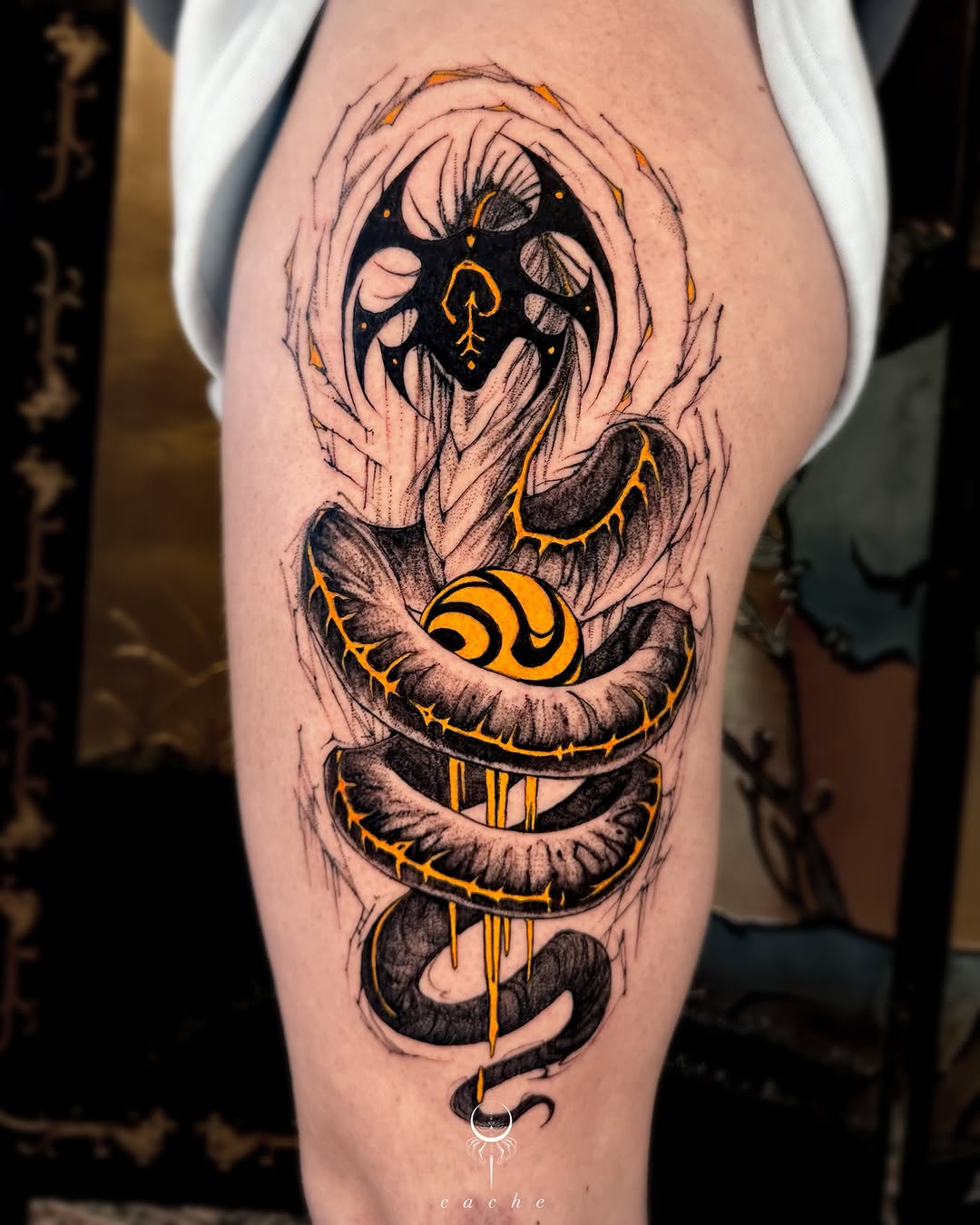 Striking black and orange thigh tattoo design