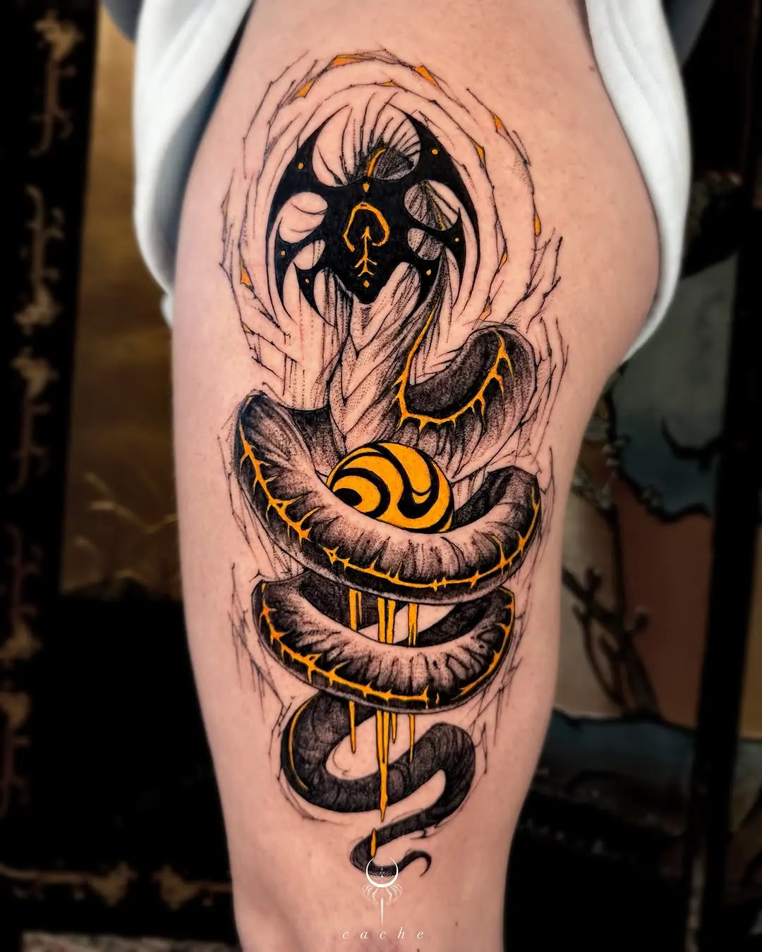 Striking black and orange thigh tattoo design